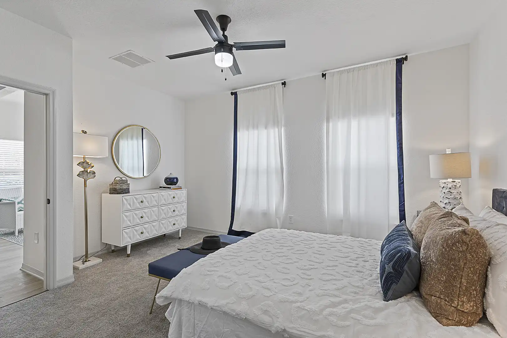 model bedroom with modern furniture, ceiling fan and carpet