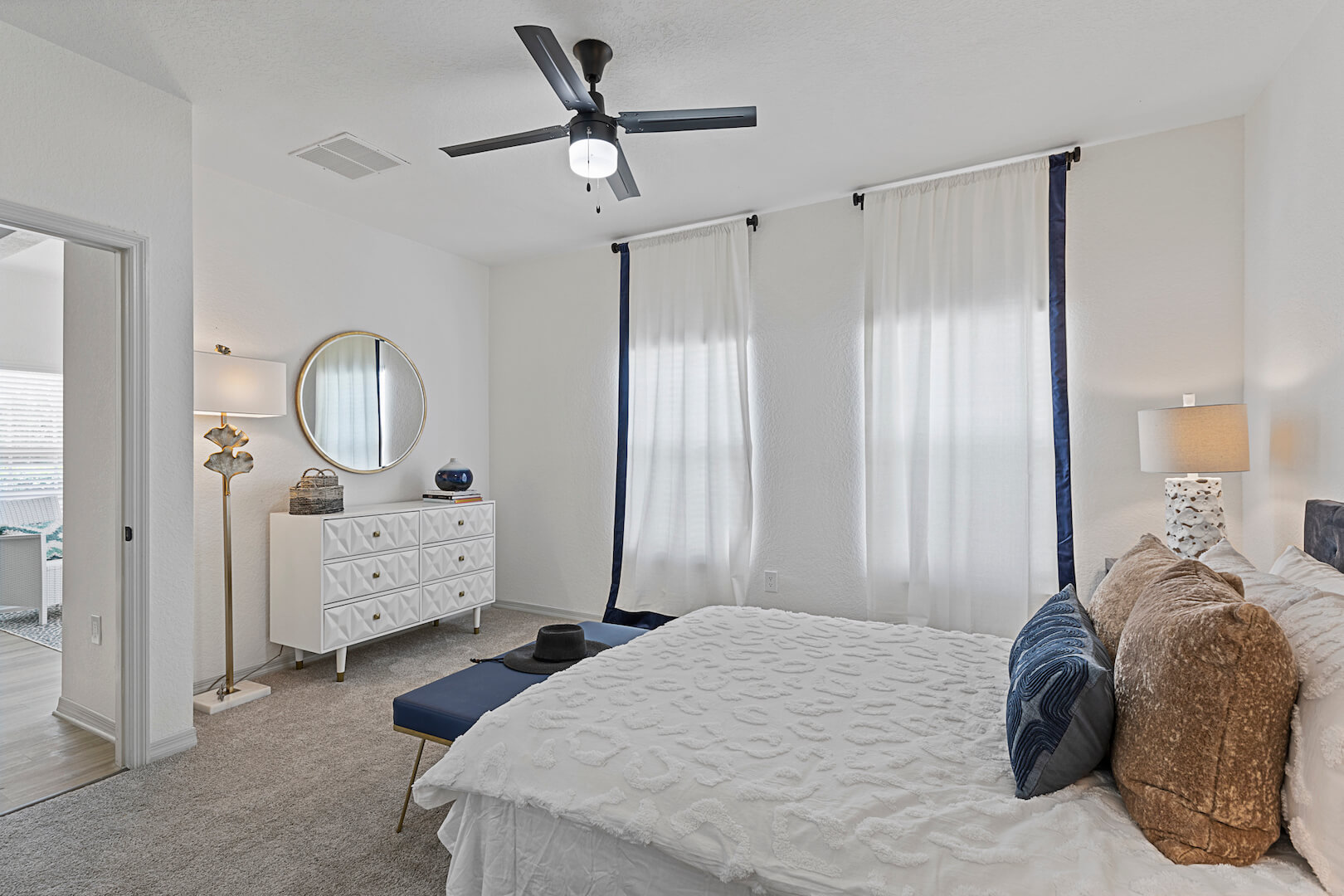 model bedroom with modern furniture, ceiling fan and carpet