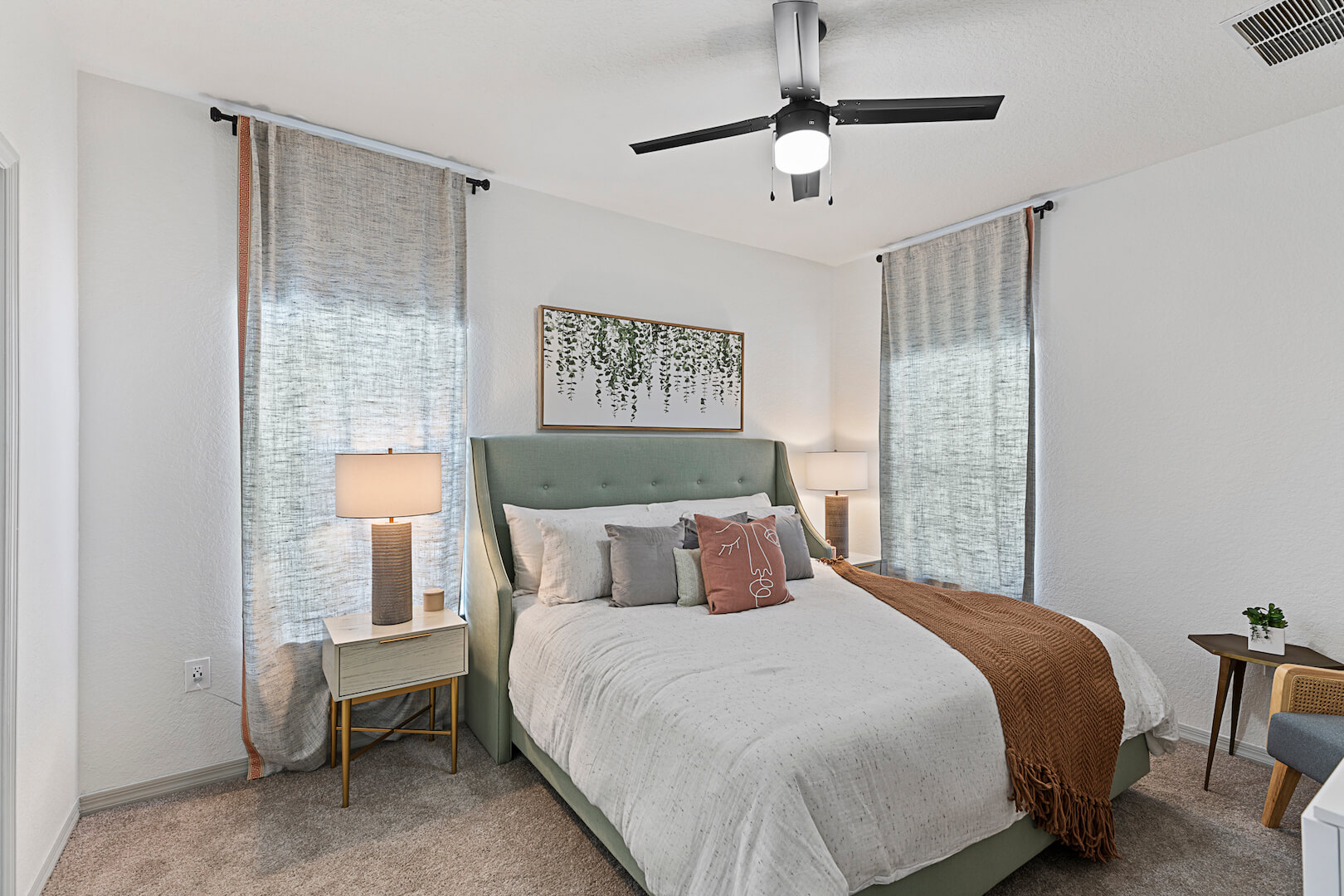 model bedroom with modern furniture, ceiling fan, carpet, and ceiling to floor curtains